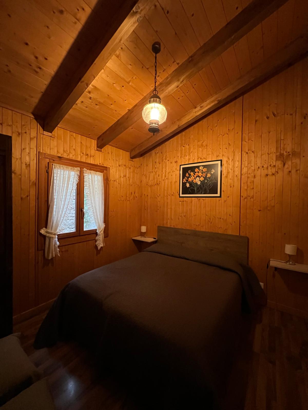 Nella fotografia la stanza da letto matrimoniale dello Chalet Vacanza Lauretana del Resort Spa La Bossola di Netro.