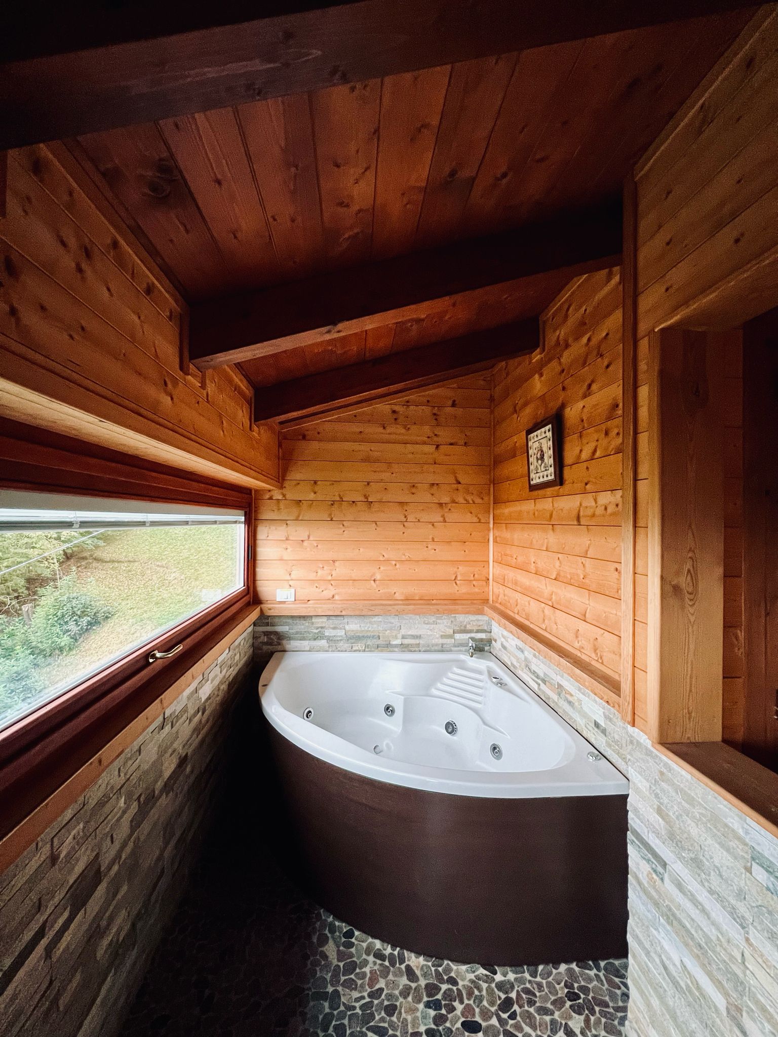 Appena dopo l'ingresso dello Chalet Vacanza Lauretana del Resort Spa La Bossola di Netro, trovi una vasca idromassaggio panoramica dalla quale puoi ammirare un fantastico panorama dalla finestra a vetri.
