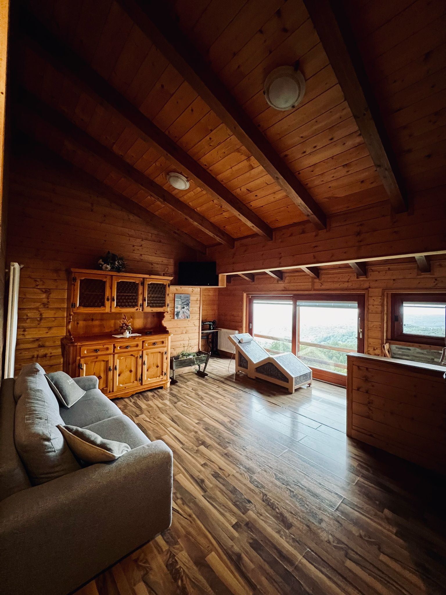 Nel salotto dello Chalet Vacanza Lauretana del Resort Spa La Bossola di Netro, trovi anche una chaise longue riscaldata dalla quale puoi ammirare un fantastico panorama dalla porta a vetri scorrevole.